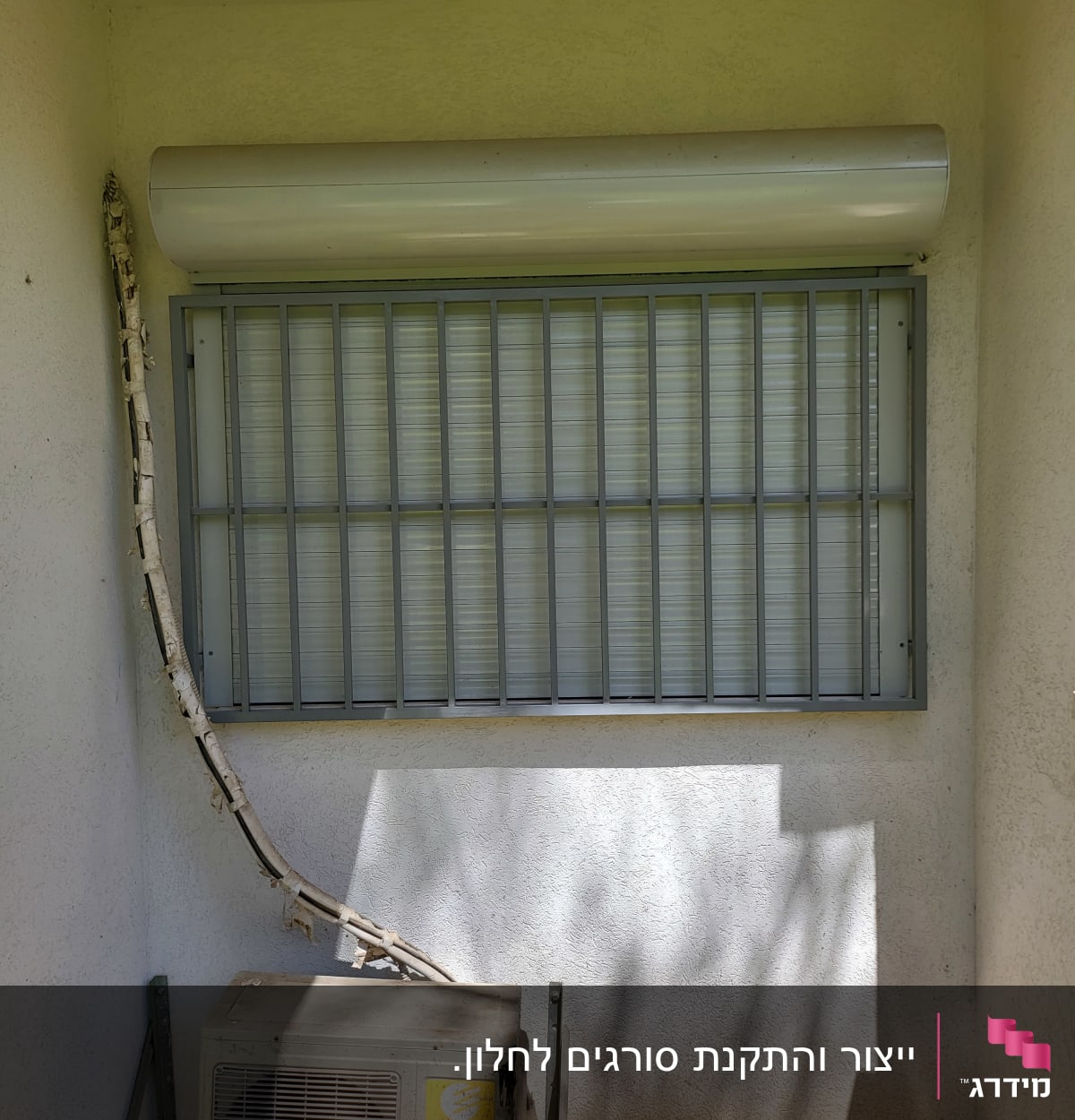 סורגי מתכת על חלון עם תריס גלילה